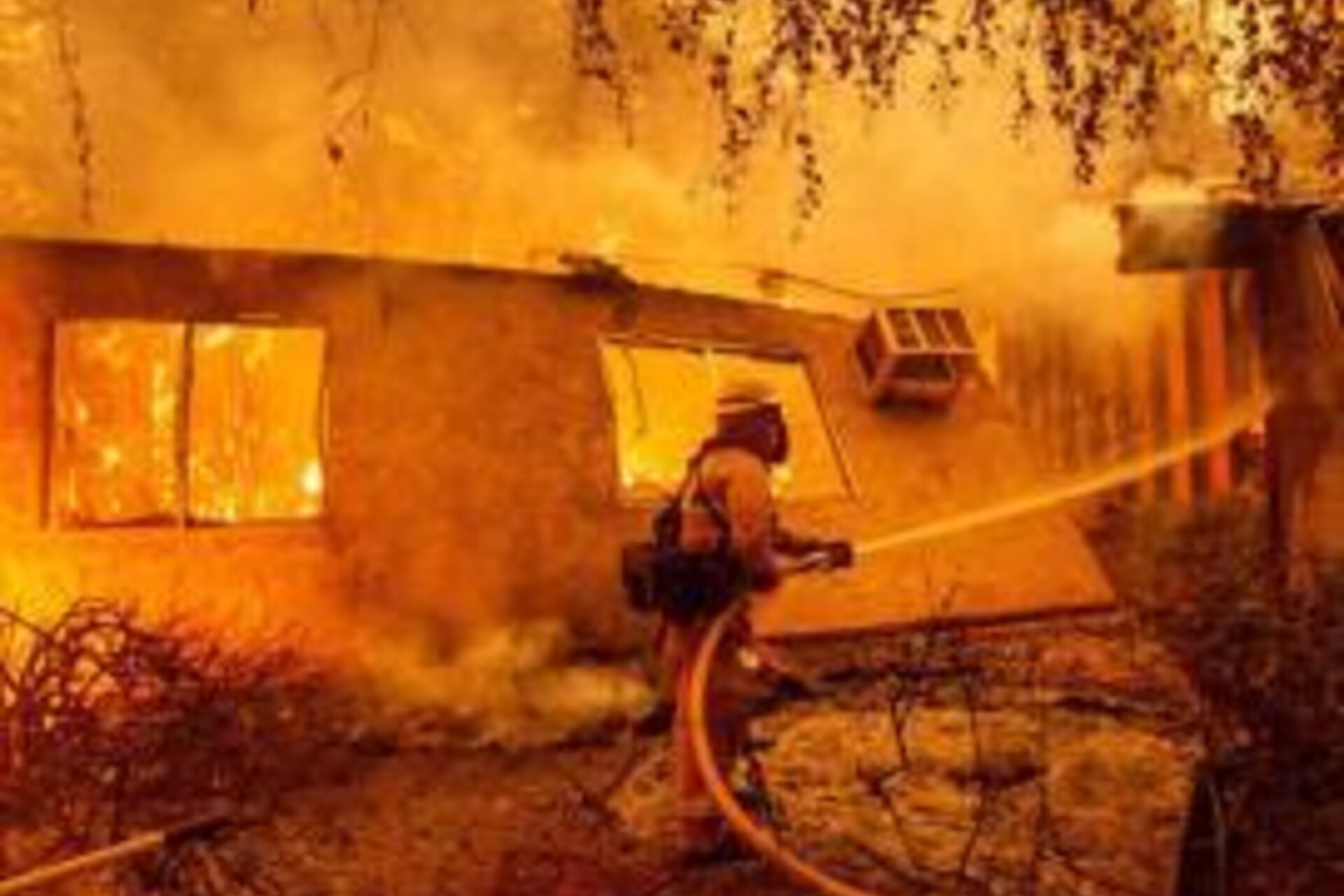 Firefighter extinguishing house fire