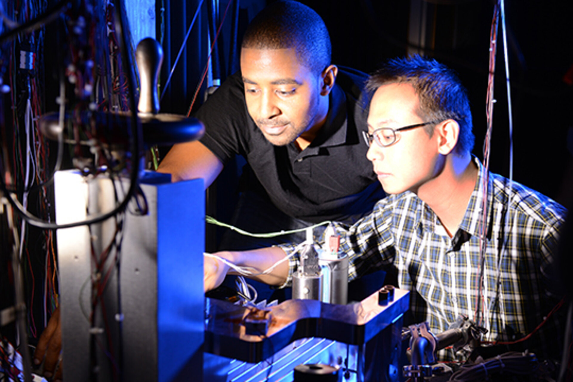 Two researchers in Fritz lab working on equipment