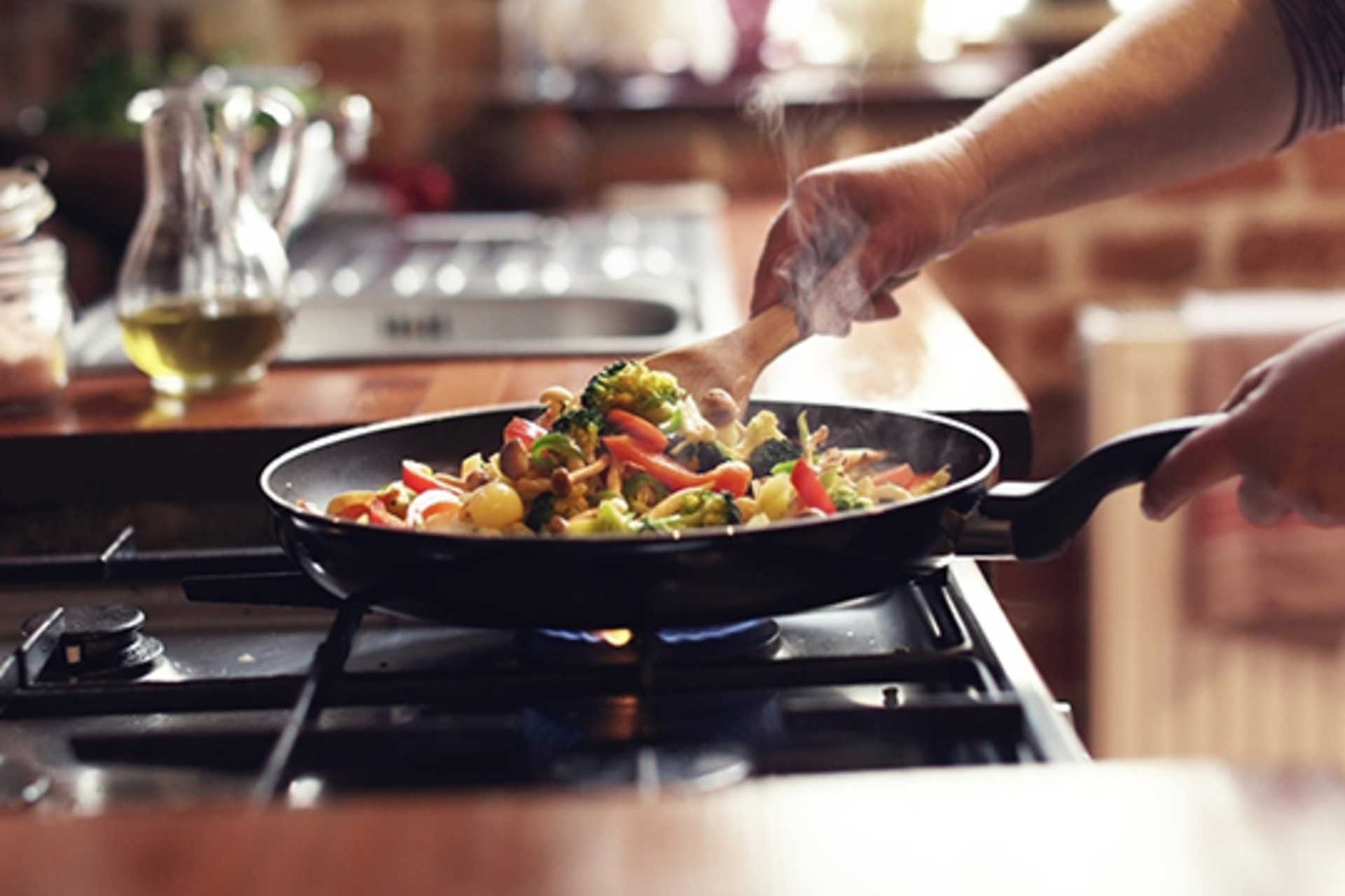 A person cooking a stir fry on a natural gas stove