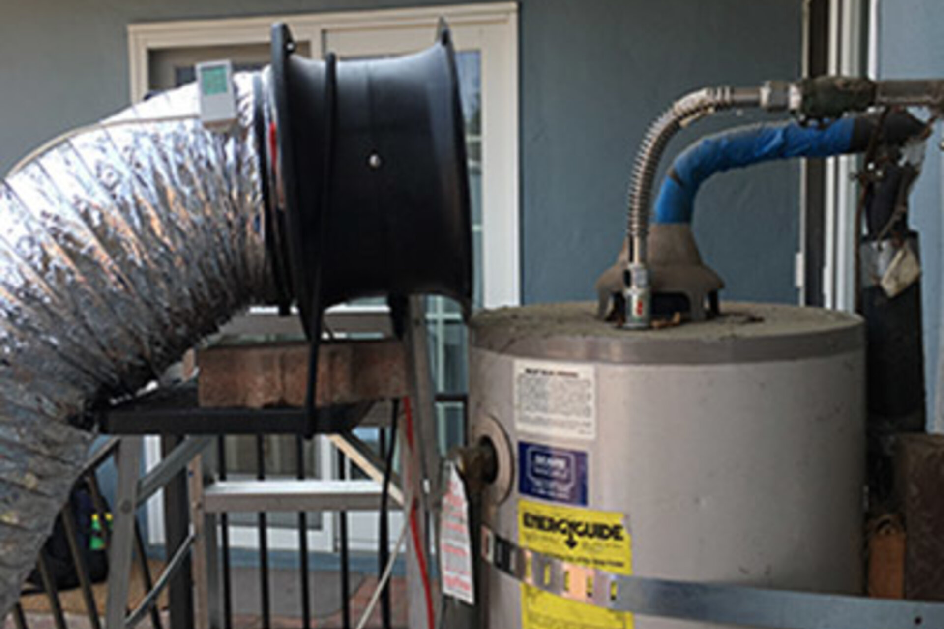 A Duct Blaster captures the methane being emitted from a conventional storage water heater. 