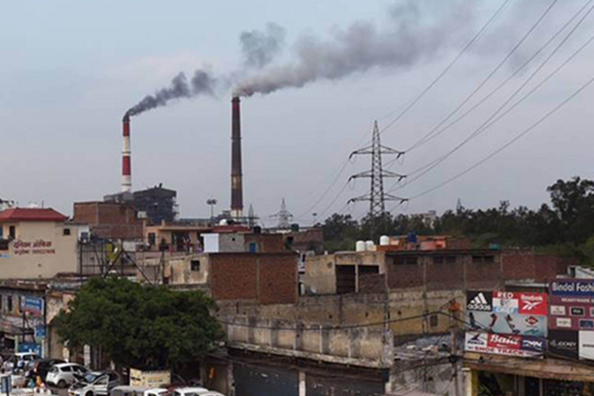 Smoke billows from two smoke stacks at the coal-based Badarpur Thermal Station in New Delhi.