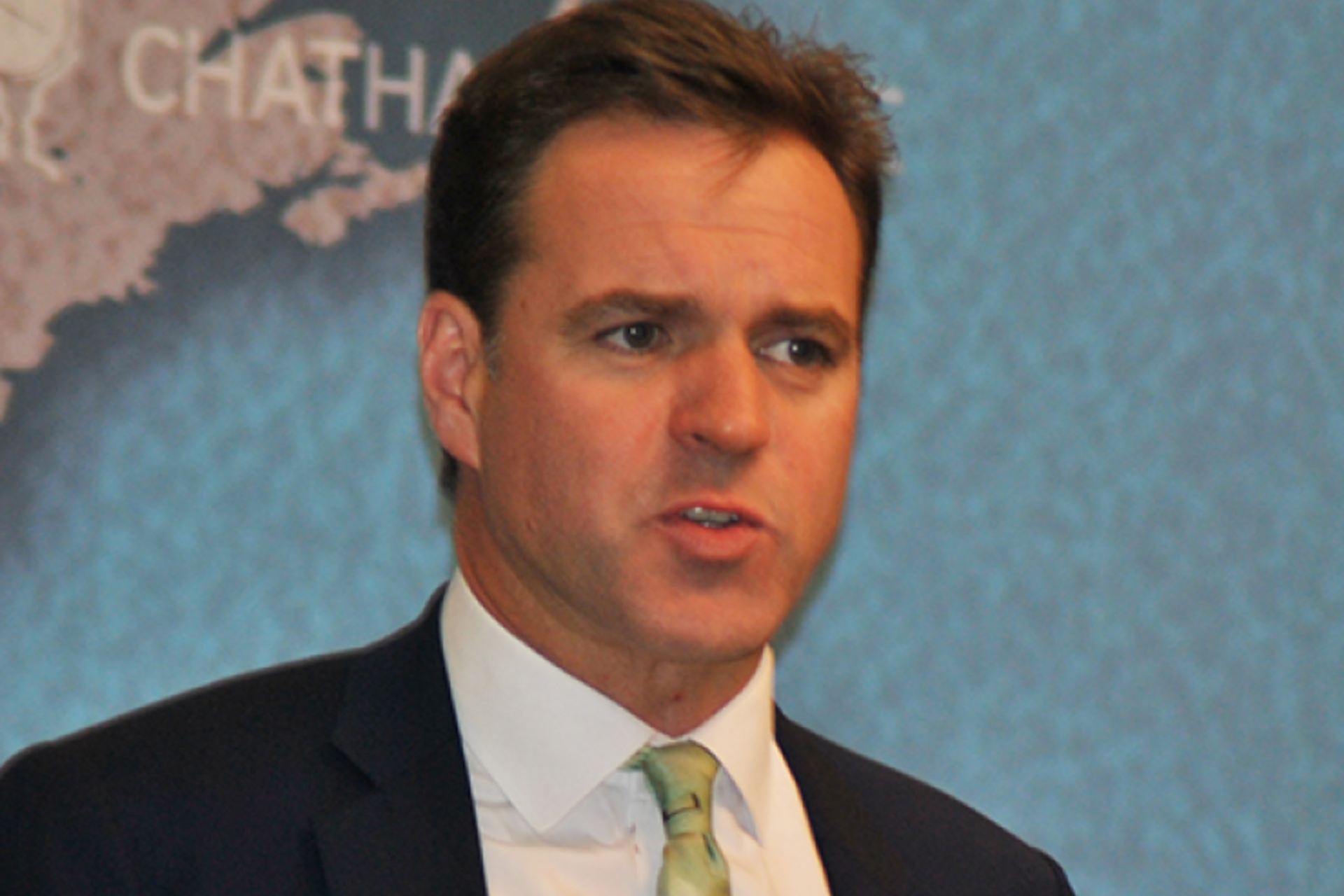 Neil Ferguson speaking in front of map