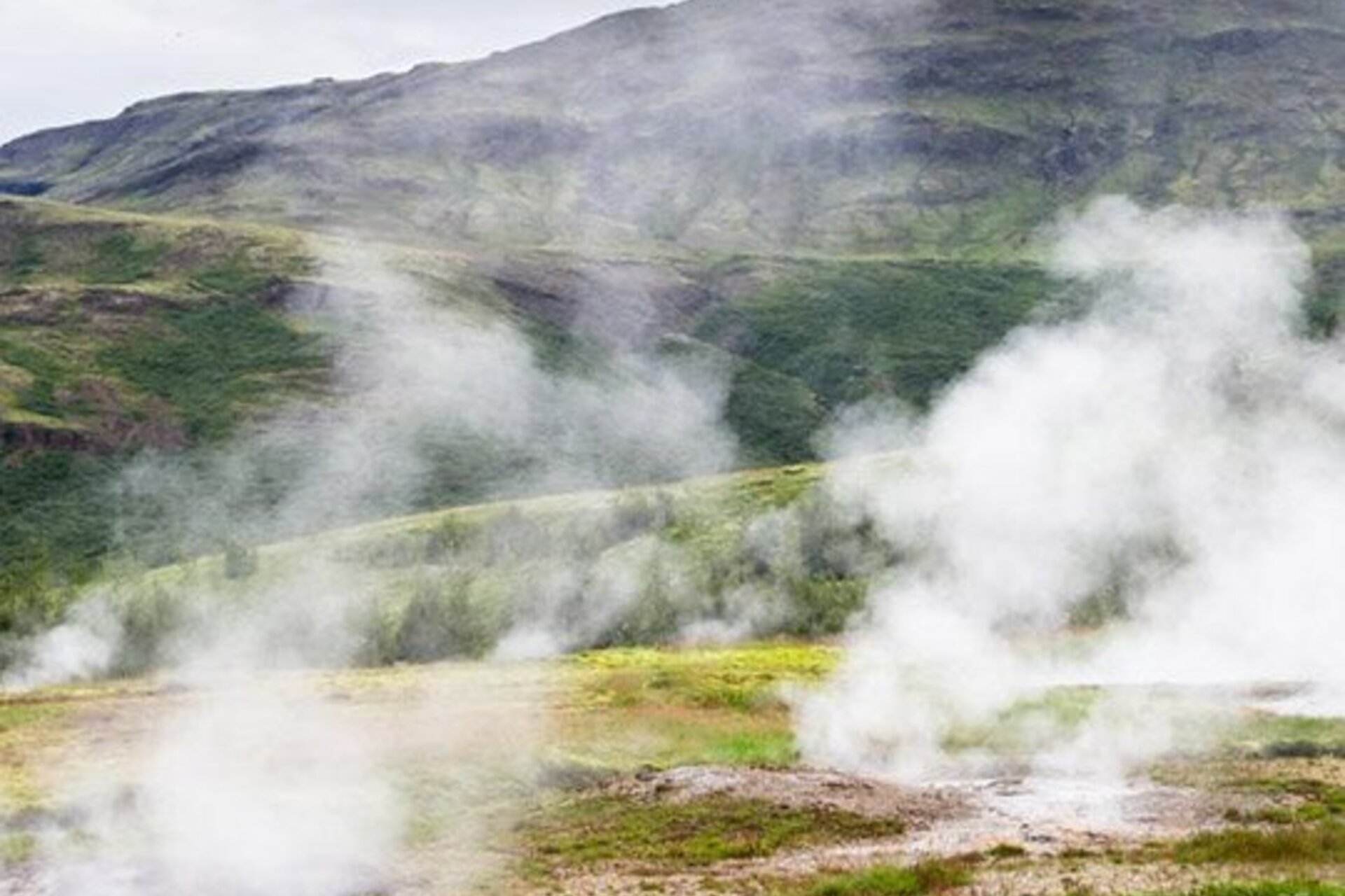 Steam rising from the ground near geothermal outlets