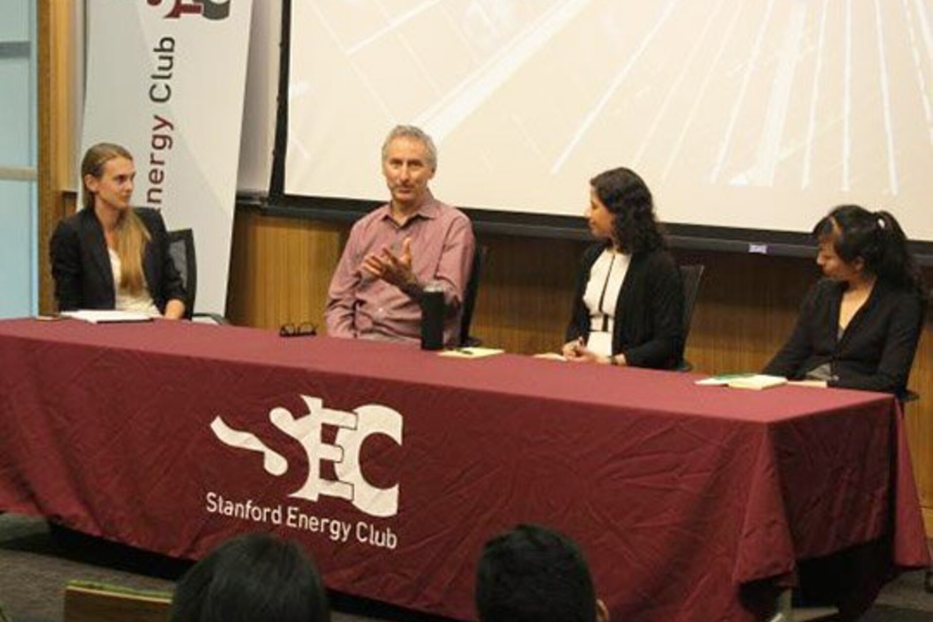 Members of Stanford Energy Club speaking at a table in the front of a classroom