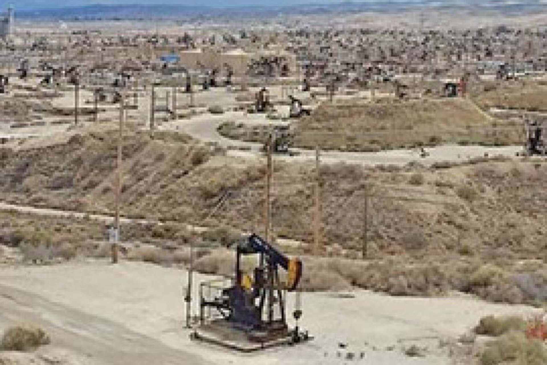 An oil pumpjack in the dry, Central California landscape