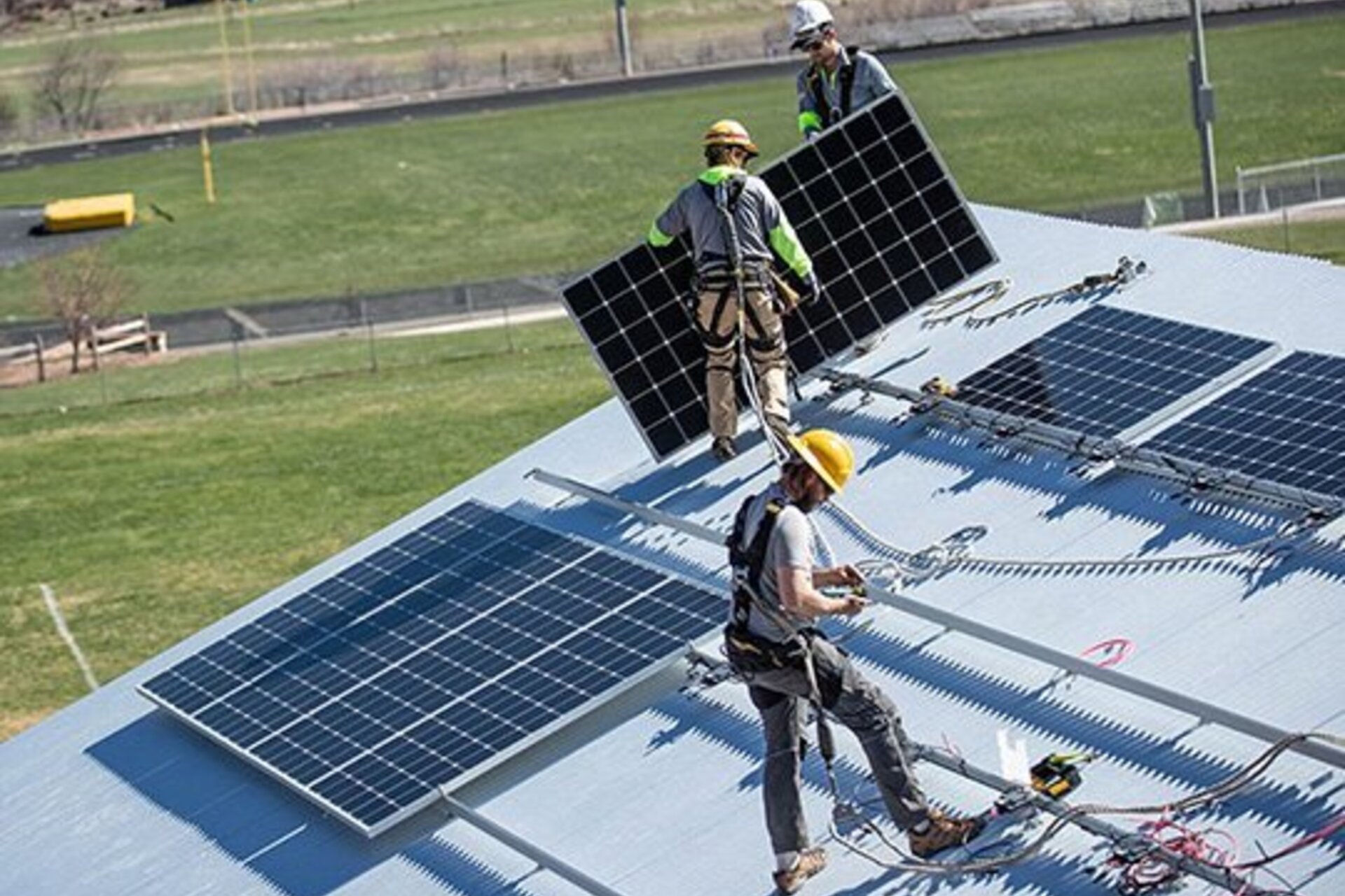 Workers install solar panels on a home