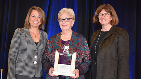 Elizabeth Moler holding award next to Catherine Jereza and Kam Moler
