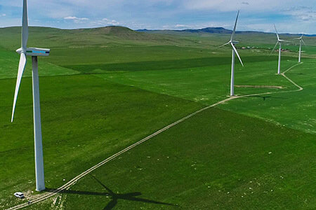 Four of the turbines on a TransAlta Renewables wind farm in Alberta, Canada that were used for the wake-steering experiment. The truck in the lower left corner of the photo gives a sense of the wind turbines’ size, less than 5%..